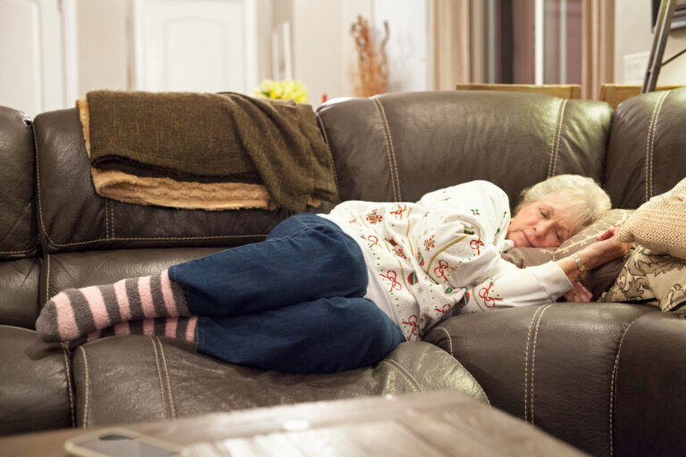 Vrouw slaapt op bank, ze heeft last van herfst- en wintermoeheid.