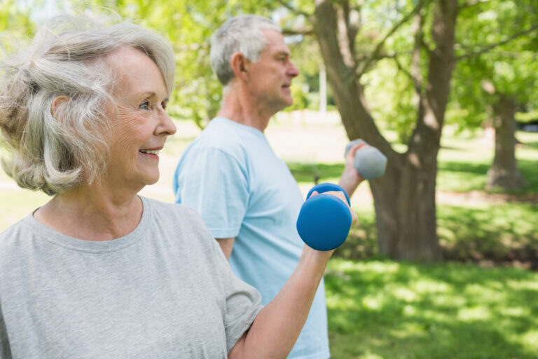 Actief blijven met parkinson Twee oude mensen sporten samen buiten en moeten actief blijven met parkinson.