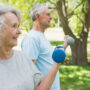 Twee oude mensen sporten samen buiten en moeten actief blijven met parkinson.
