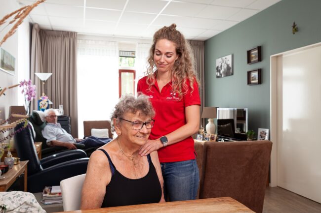 Fysiotherapeut helpt vrouw met stijve nek die ze heeft gekregen bij het opstaan.