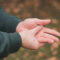 Man zit aan zijn hand omdat hij last heeft van tintelingen in zijn hand en vingers.