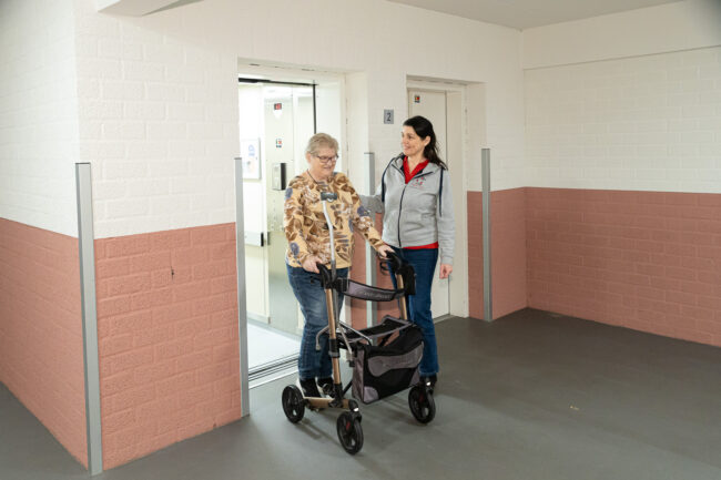 spier- en gewrichtspijn door kou Fysiotherapeut helpt oudere vrouw met bewegen tegen spier- en gewrichtspijn door kou.